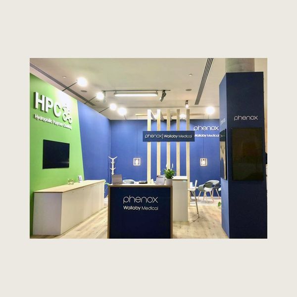 Messestand eines Medizintechnik-Unternehmens in Blau und Grün mit Lounge-Bereich